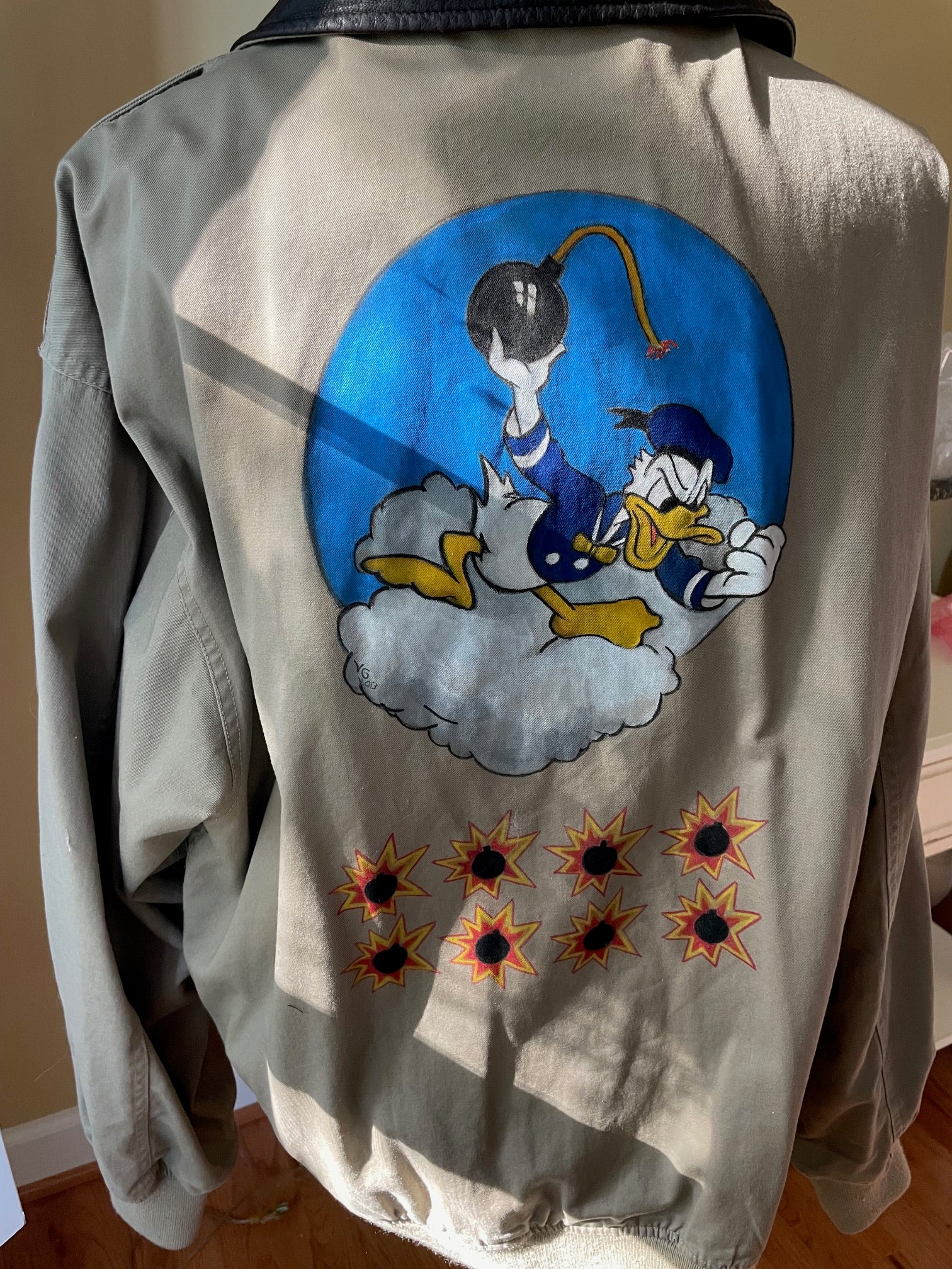 A10 canvas jacket back with Donald Duck handpainted to surface, and 8 mission marks shaped like lit bombs